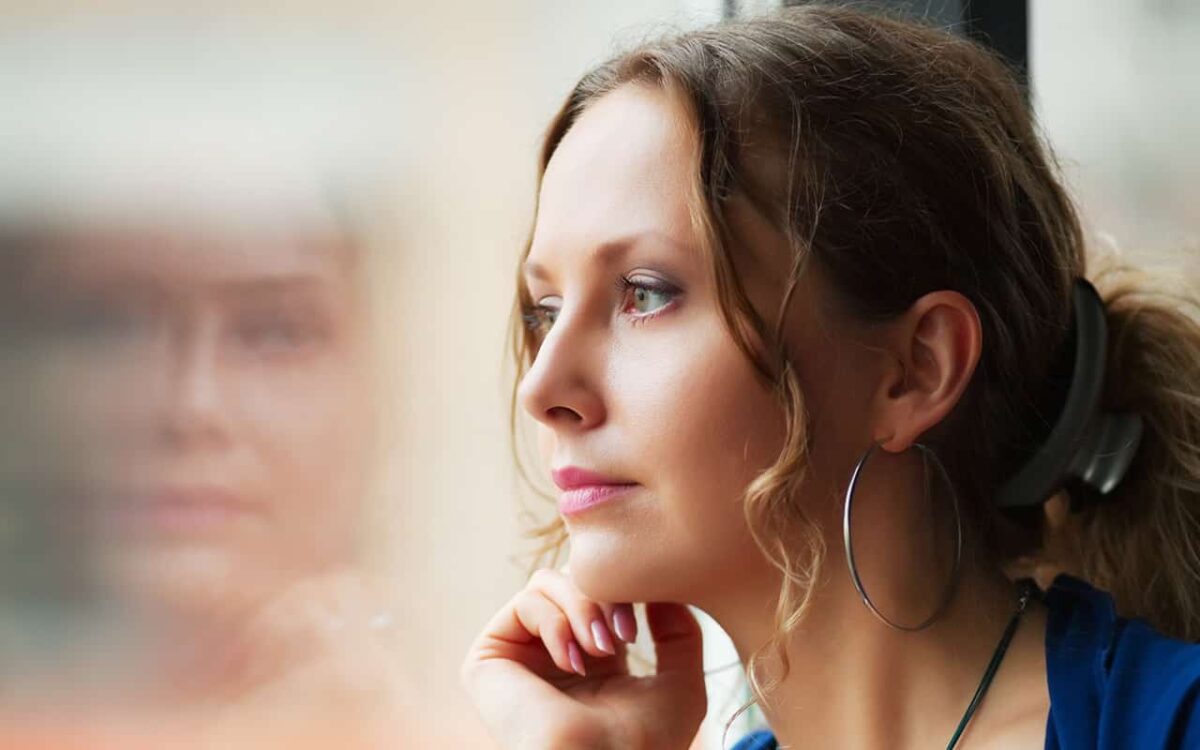 Eine Frau, die nachdenklich aus einem Fenster sieht