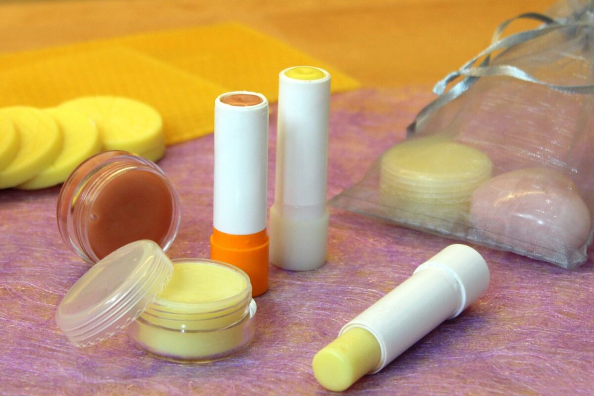 Selbstgemachte Lippenpflege aus natürlichen Zutaten auf lila Hintergrund.