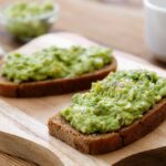 Gurken Avocado Aufstrich auf einem Holzbrett