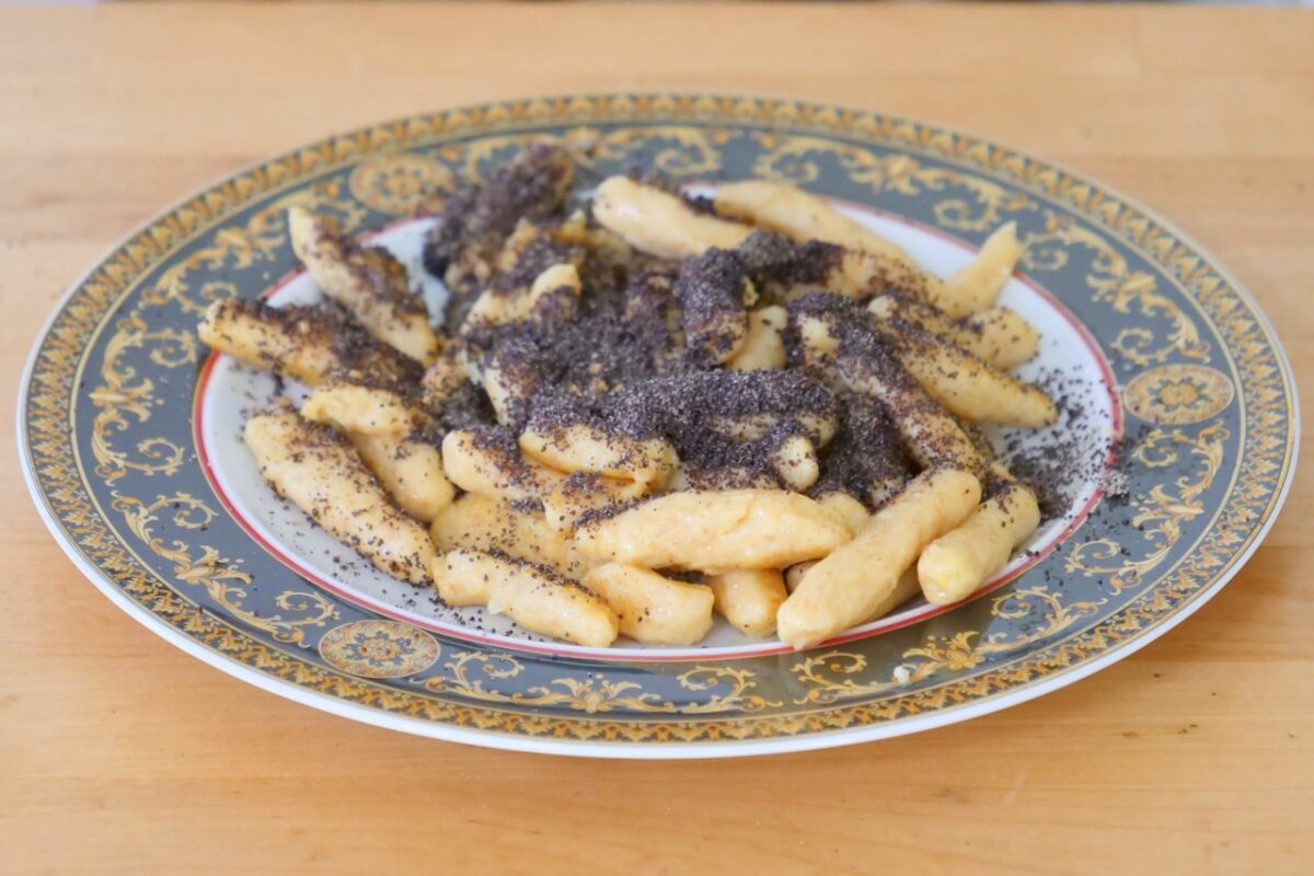 Hausgemachte Schupfnudeln mit Mohn auf edlem Teller; eine süße Verführung aus Kartoffelteig.